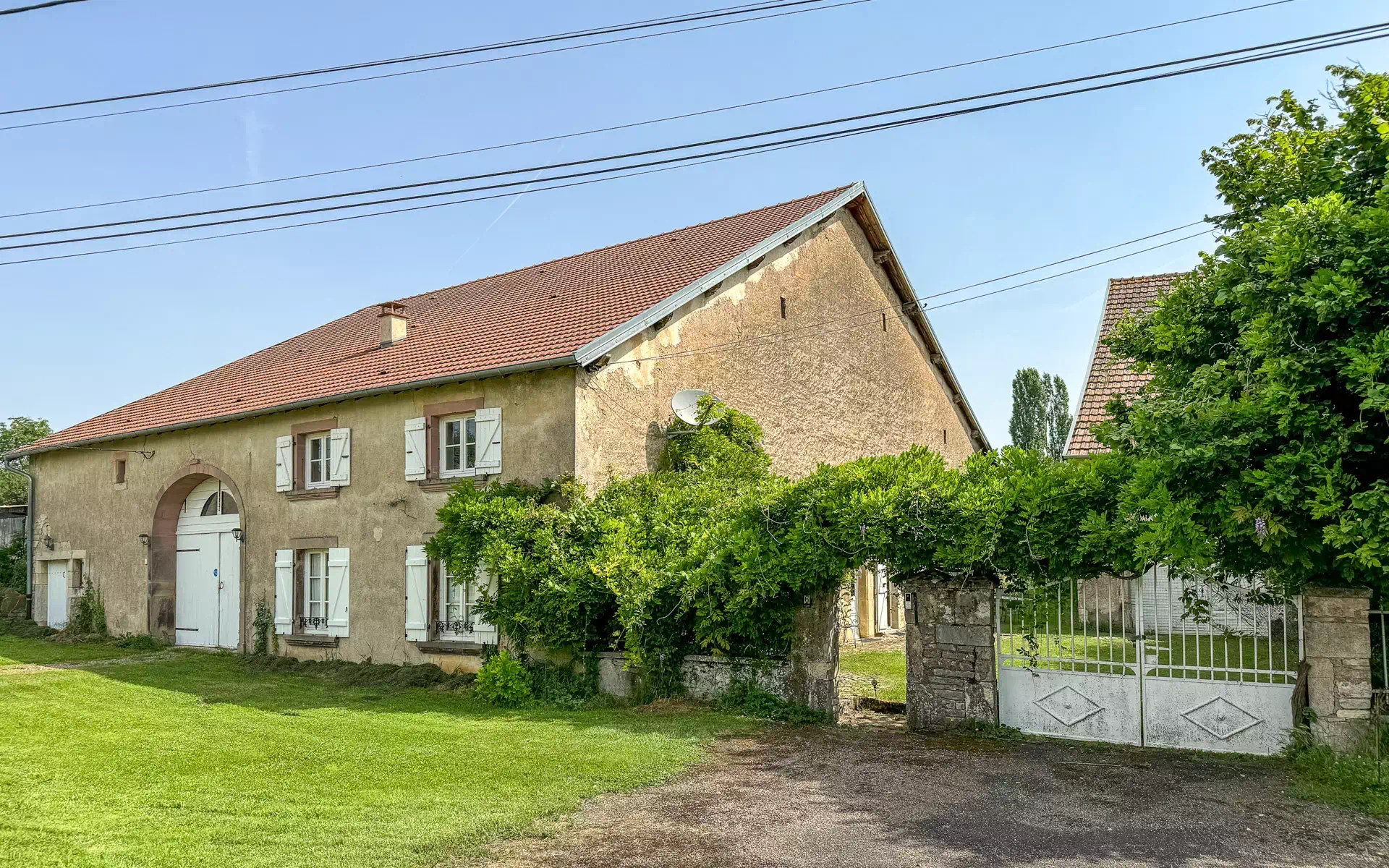 Jolie façade et verdure de la Ferme rénovée à proximité de Vesoul - Arrière-Cour, agence immobilière spécialisée à Vesoul