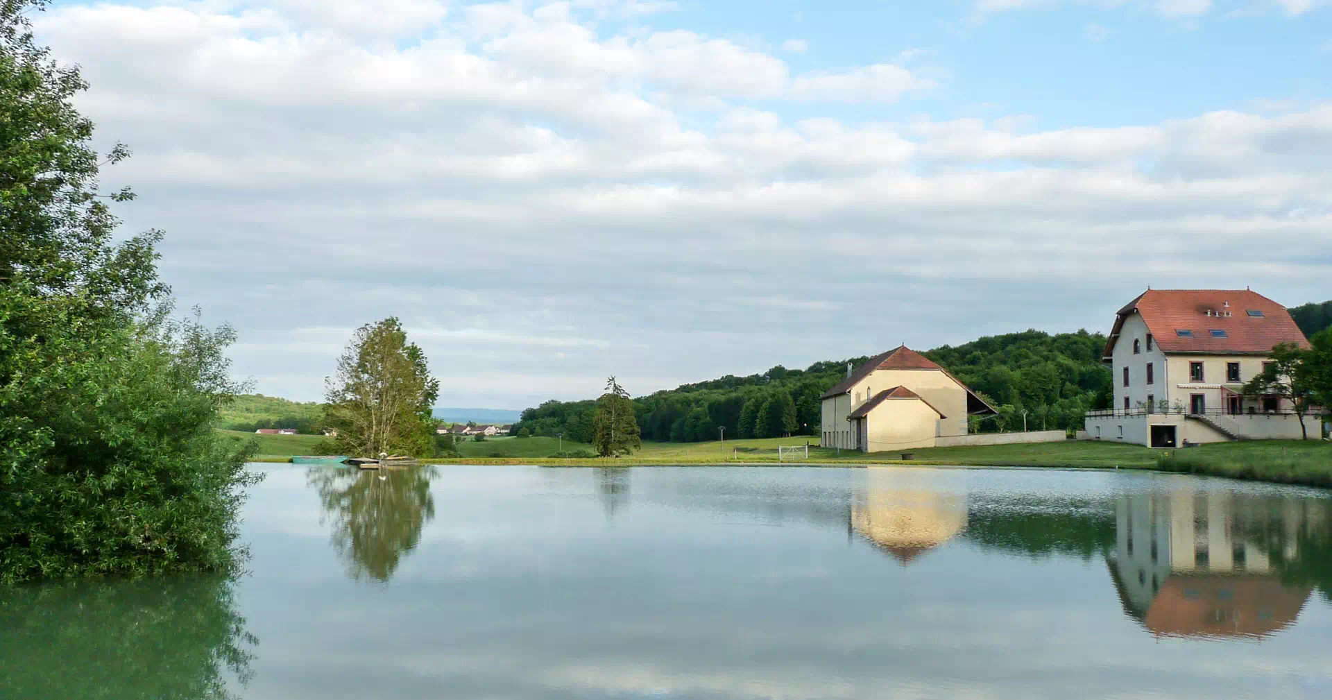 Vue de ll'étang de la ferme rénovée avec terres agricoles BIO à vendre proche de Montbéliard – Arrière-Cour, agence immobilière spécialisée à Montbéliard