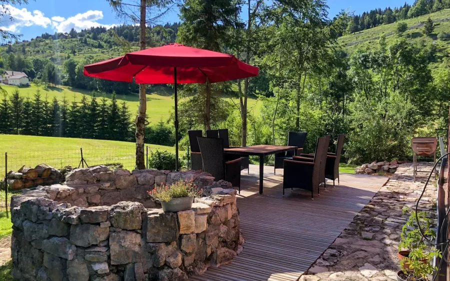 Terrasse extérieure de la ferme à Foncine avec vue sur la montagne – Arrière-Cour, agence spécialisée dans le Jura