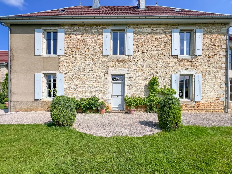 Façade en pierres de l'Ancien Presbytère dans le Doubs - Arrière-Cour, agence immobilière spécialisée dans le Doubs