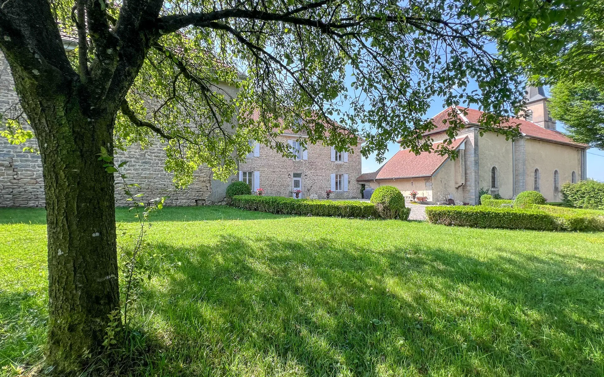 Verdure autour de l'Ancien Presbytère dans le Doubs - Arrière-Cour, agence immobilière spécialisée dans le Doubs