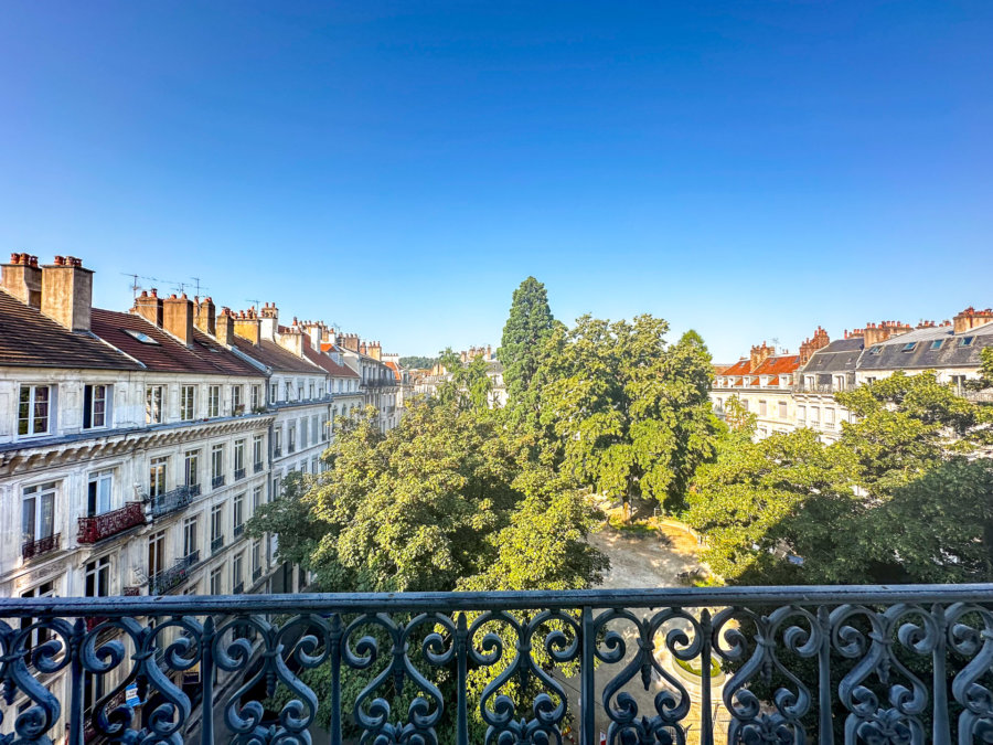 Vue ensoleillée sur le square de l’appartement Haussmannien square Saint-Amour à Besançon - Arrière-Cour, agence immobilière de prestige et de caractère à Besançon