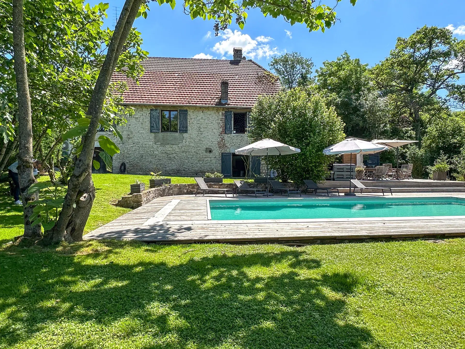 Façade en pierres et piscine extérieure de la maison vigneronne proche d'Arc-et-Senans - Arrière-Cour immobilier, agence immobilière spécialisée dans le Doubs