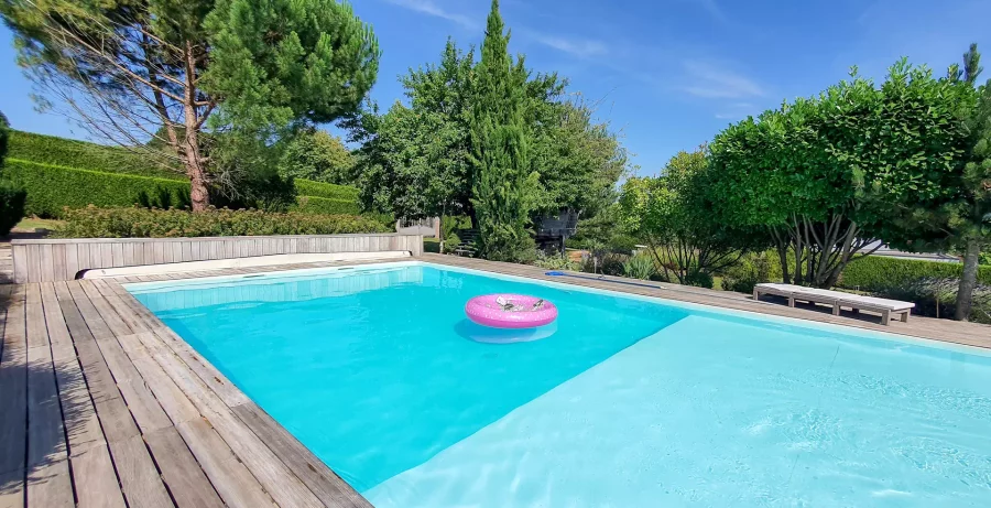 Piscine et bouée rose de la Villa d'architecte à Port-sur-Saône - Arrière-Cour, agence immobilière spécialisée en Bourgogne Franche-Comté