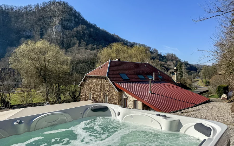 Vue et spa de l'auberge dans la vallée de Cusance à vendre - Arrière-Cour, agence immobilière spécialisée en le Doubs
