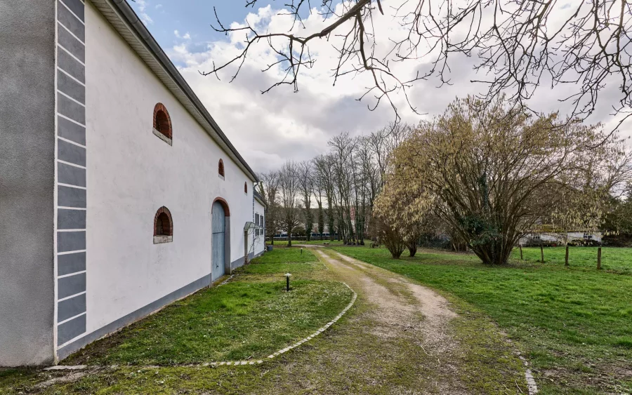 Bâtiment et verdure de la propriété d'exception à Thervay - Arrière-Cour, agence immobilière spécialisée dans le Jura