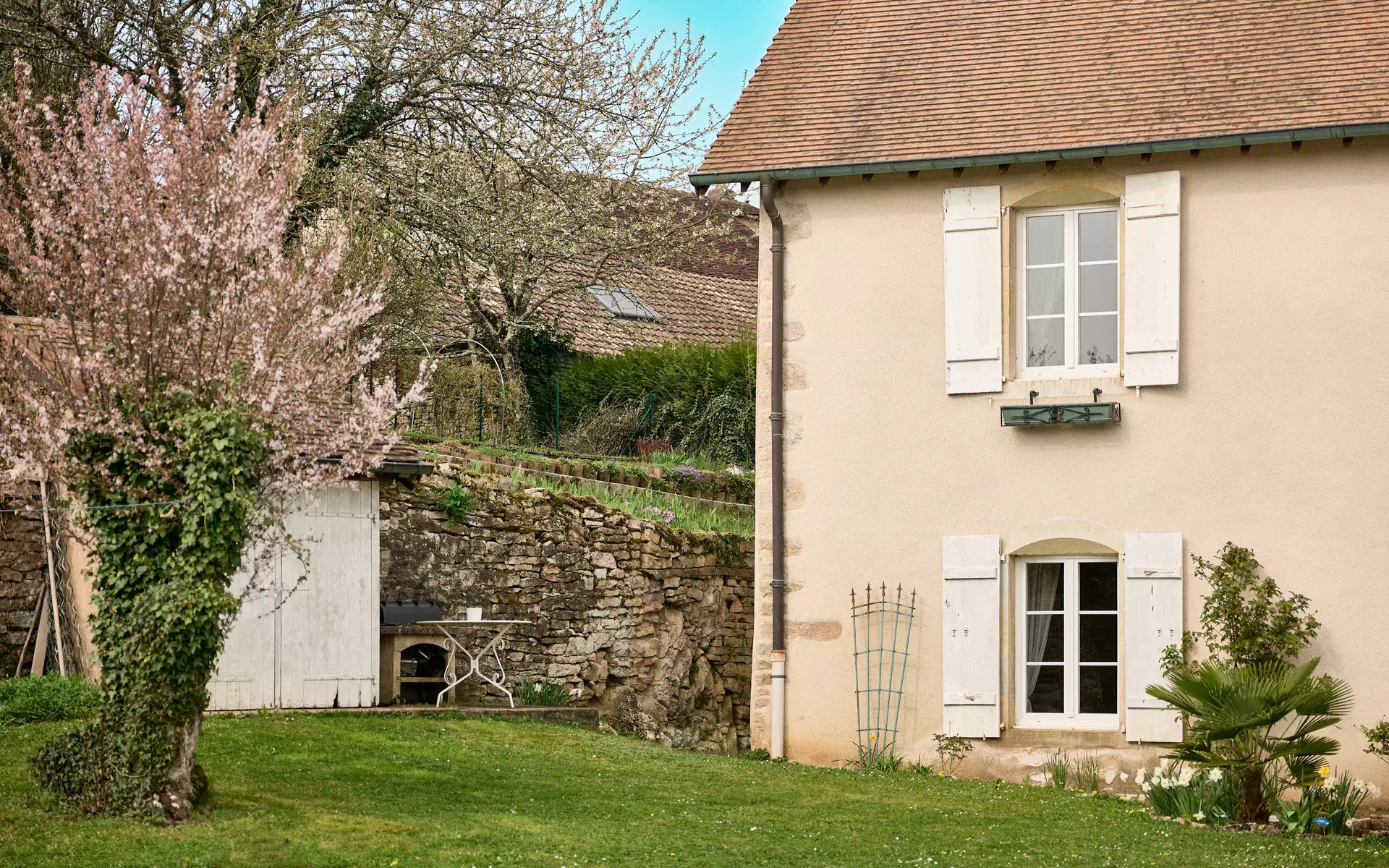 Verdure et façade de l'ancien relais de poste proche de Besançon à vendre - Arrière-Cour, agence immobilière spécialisée à Besançon
