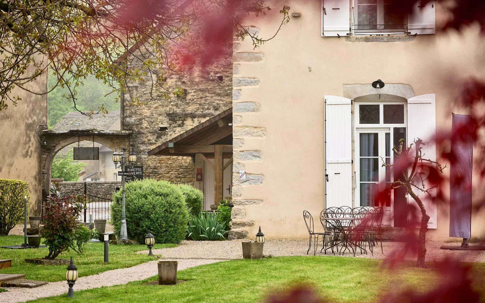 Verdure et façade de la maison vigneronne à Château-Chalon à vendre - Arrière-Cour, agence immobilière spécialisée à Jura