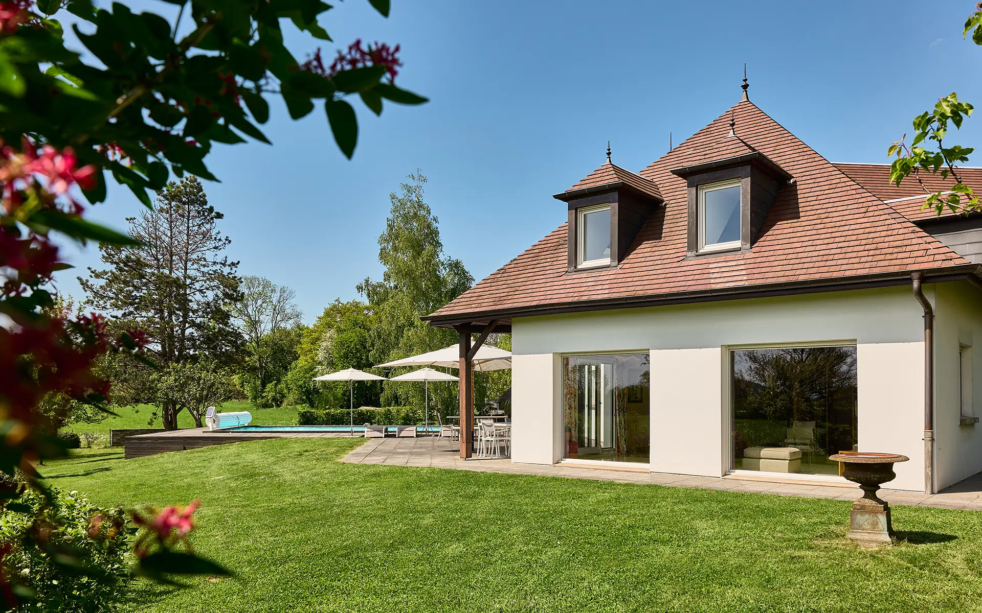 Vue Façade - demeure lumineuse avec piscine aux abords de Besançon à vendre - Arrière-Cour, agence immobilière spécialisée dans le Doubs