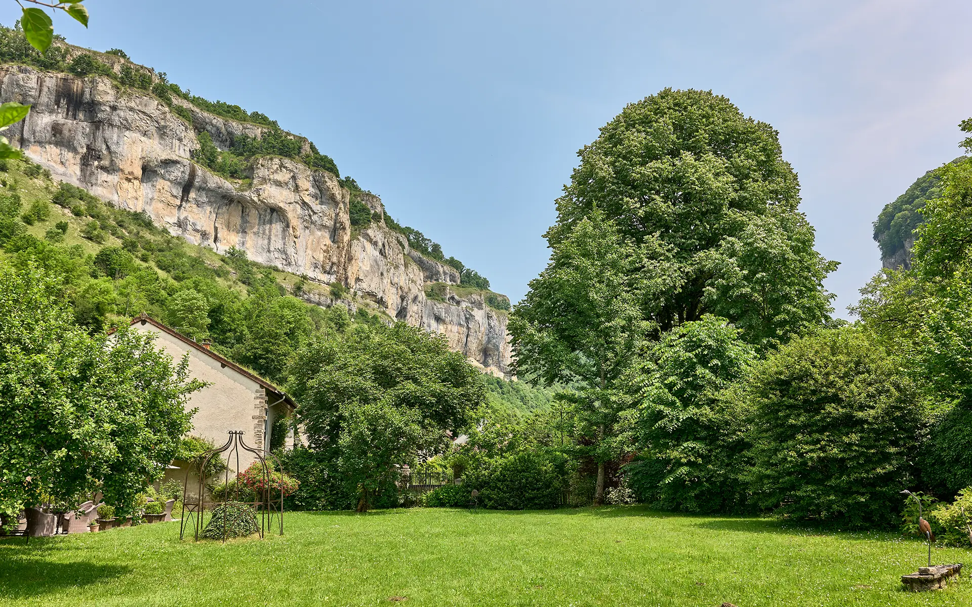 Vue du jardin de la maison avec chambre d'hôtes à Baume-les-Messieurs à vendre - Arrière-Cour, agence immobilière spécialisée dans le Jura