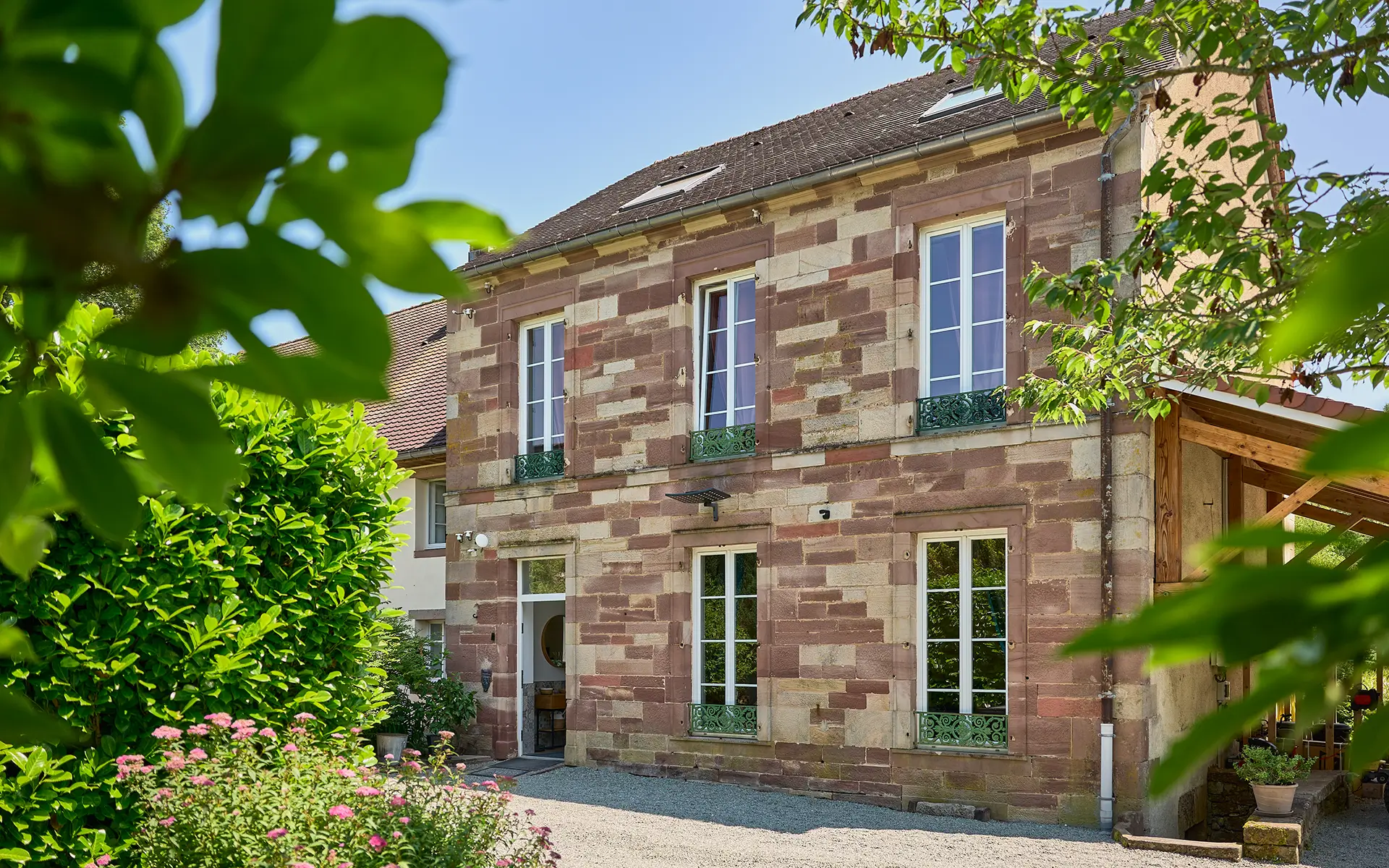 Façade en pierre de la maison de maître avec gîte et étang à Lure à vendre - Arrière-Cour, agence immobilière spécialisée en Haute-Saône