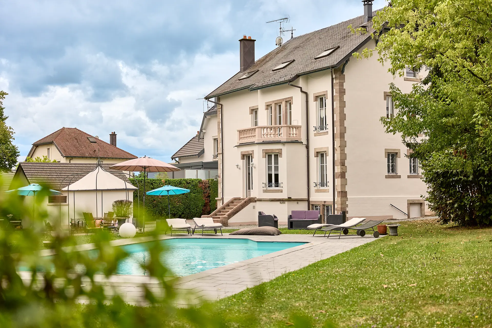Façade et piscine de la maison bourgeoise rénovée au centre de Luxeuil-les-Bains à vendre - Arrière-Cour, agence immobilière spécialisée en Haute-Saône