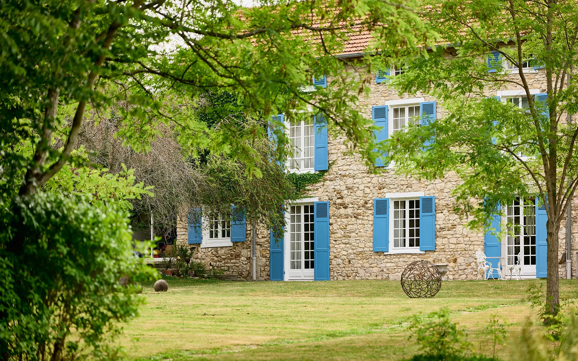 Façade et verdure de la maison ancienne à Igny à vendre - Arrière-Cour, agence immobilière spécialisée en Haute-Saône