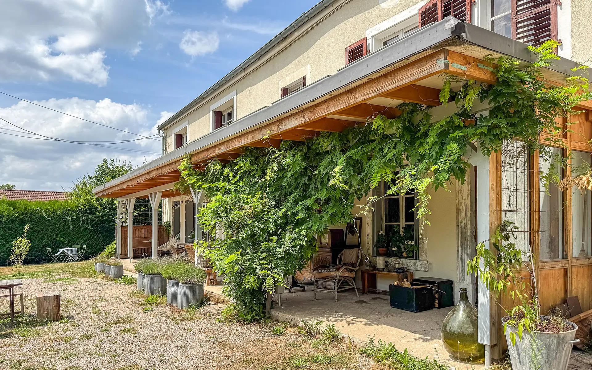 Façade fleurie de la maison de maître à Passavant-la-Rochère à vendre - Arrière-Cour, agence immobilière spécialisée en Haute-Saône