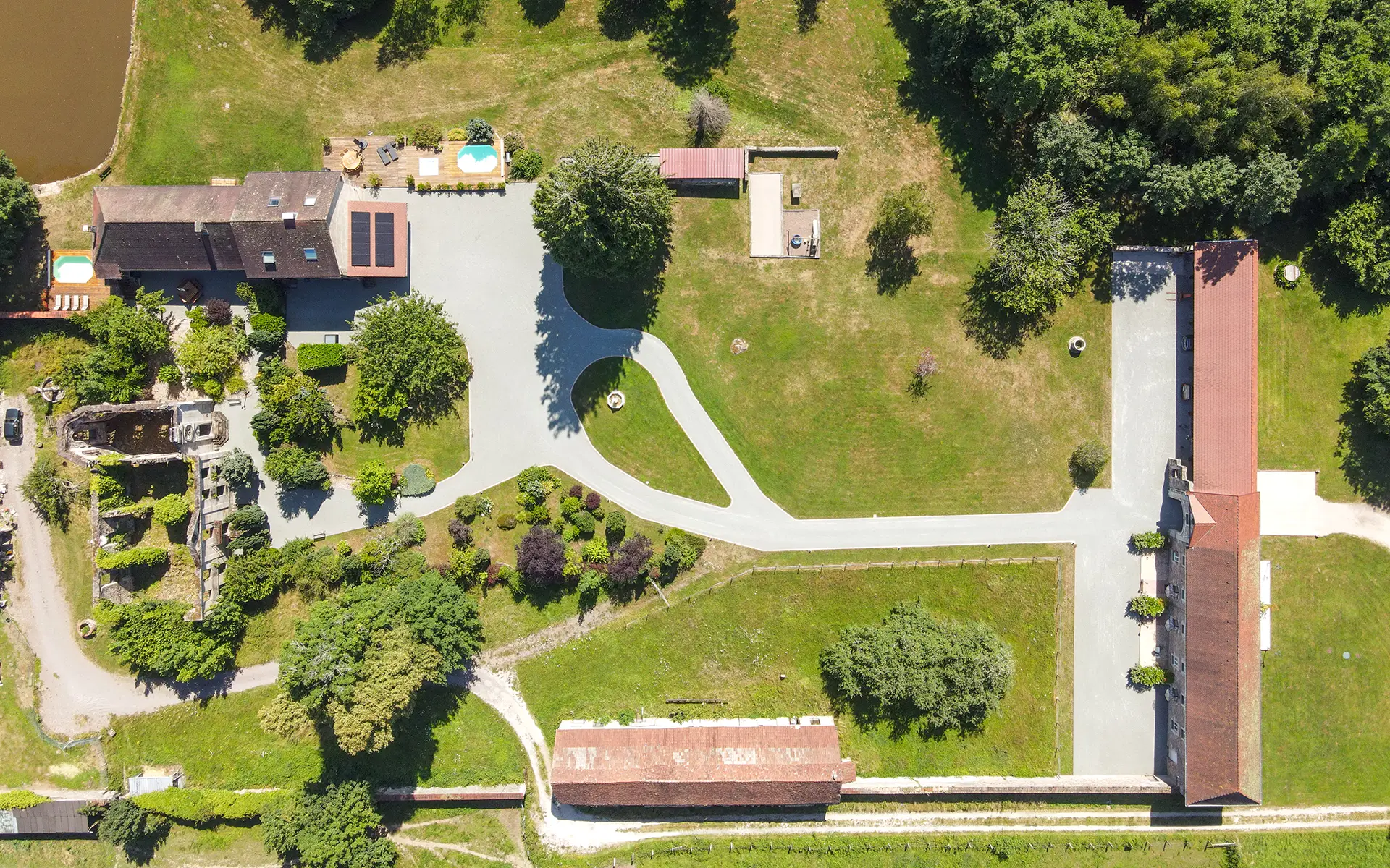 Vue de la propriété de la maison de maître avec gîte et étang à Lure à vendre - Arrière-Cour, agence immobilière spécialisée en Haute-Saône