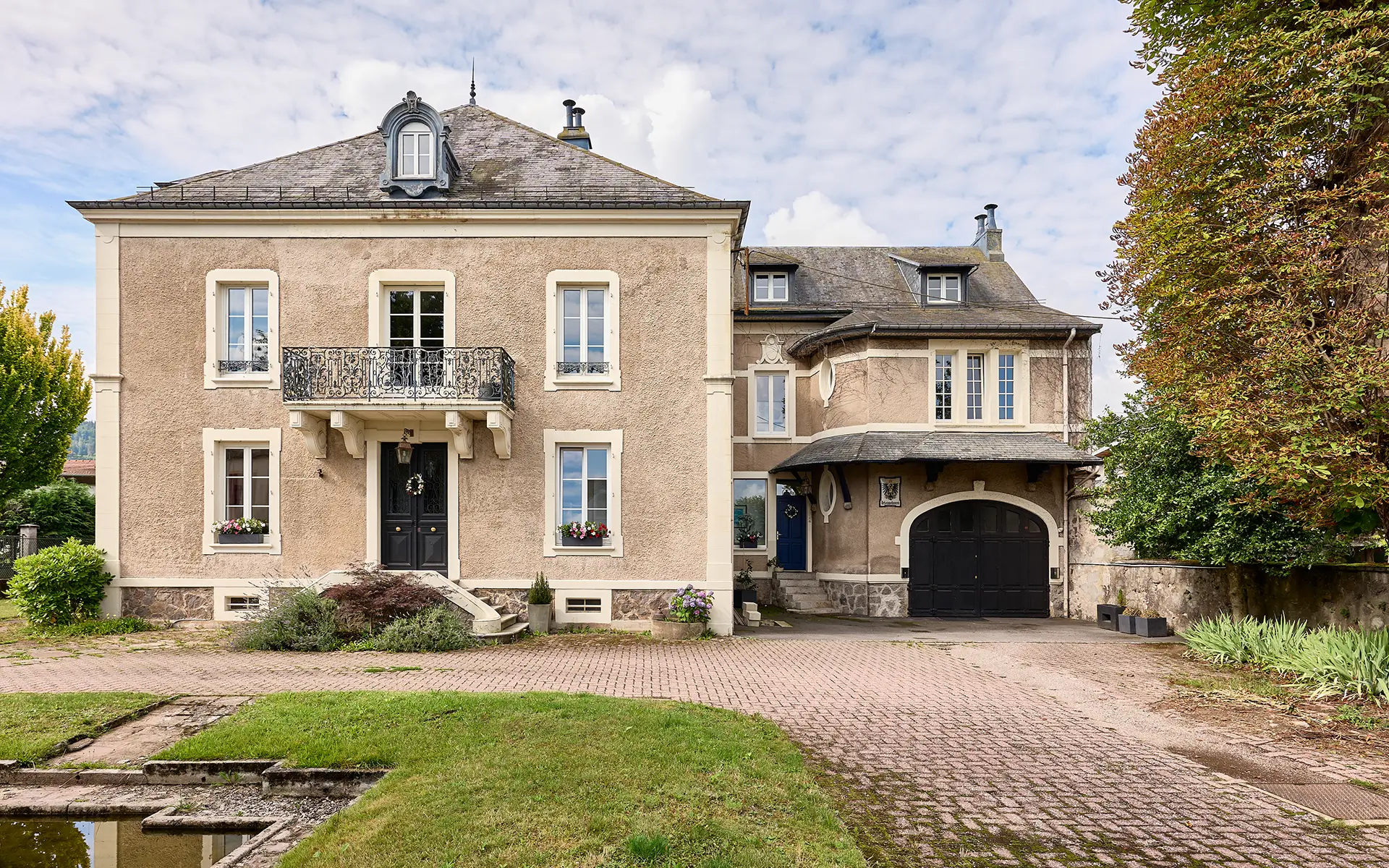 Façade de la demeure familiale avec jardin en coeur de ville vosgien à vendre - Arrière-Cour, agence immobilière spécialisée en Haute-Saône