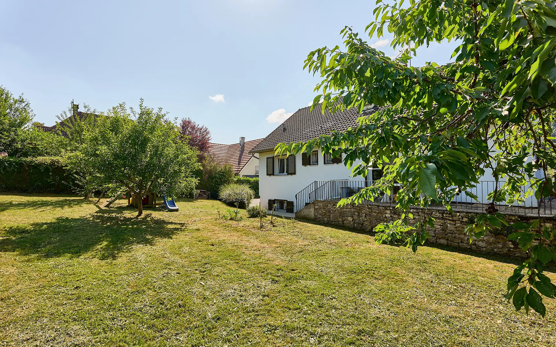 Façade et jardin de la maison avec piscine dans le quartier Velotte à Besançon à vendre - Arrière-Cour, agence immobilière spécialisée dans le Doubs