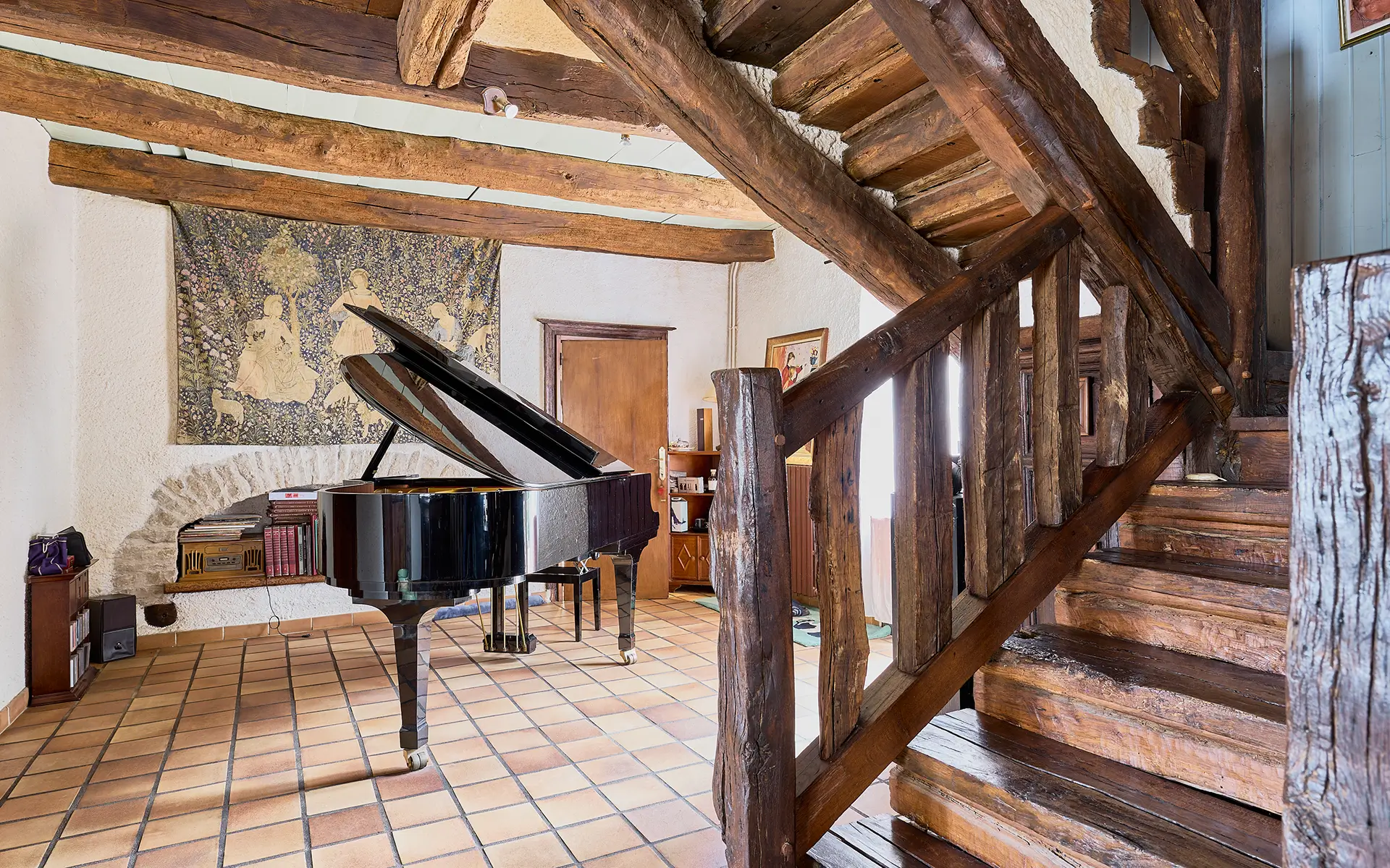 Escalier et le piano de la ferme rénovée proche de Dole à vendre - Arrière-Cour, agence immobilière spécialisée dans le Jura
