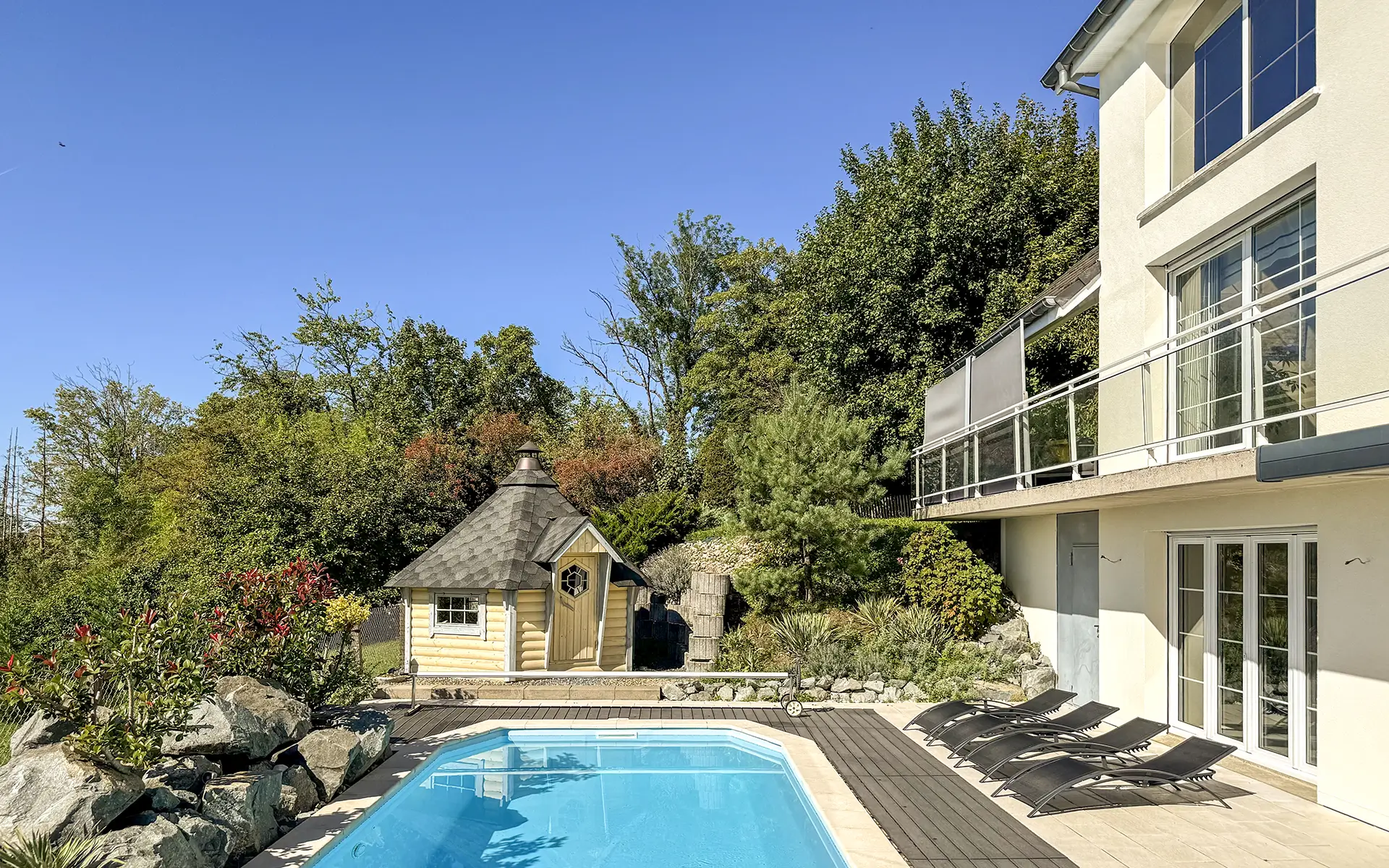 Façade et piscine de la villa avec piscine proche de Montbéliard à vendre - Arrière-Cour, agence immobilière spécialisée dans le Doubs
