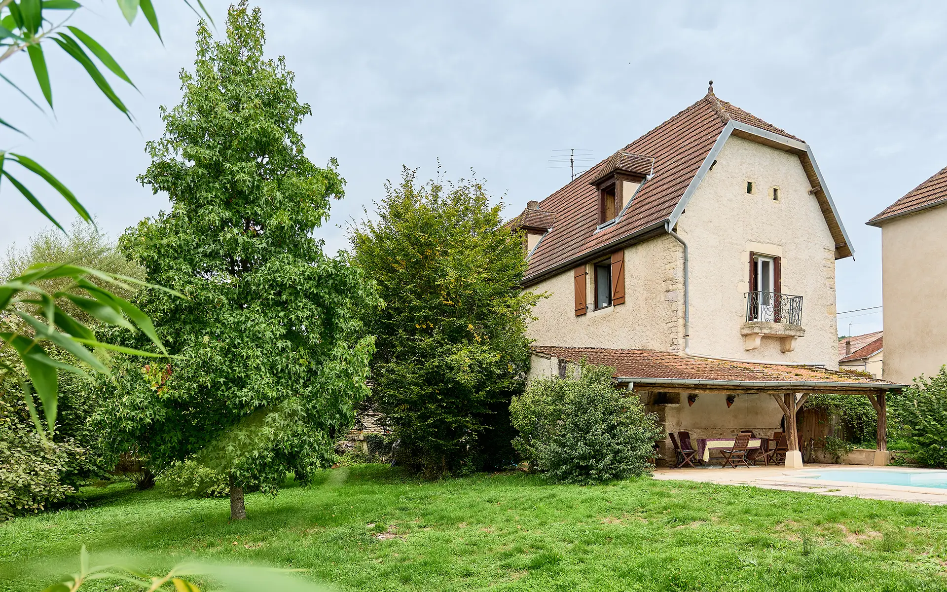 Jardin et façade de la ferme rénovée proche de Dole à vendre - Arrière-Cour, agence immobilière spécialisée dans le Jura