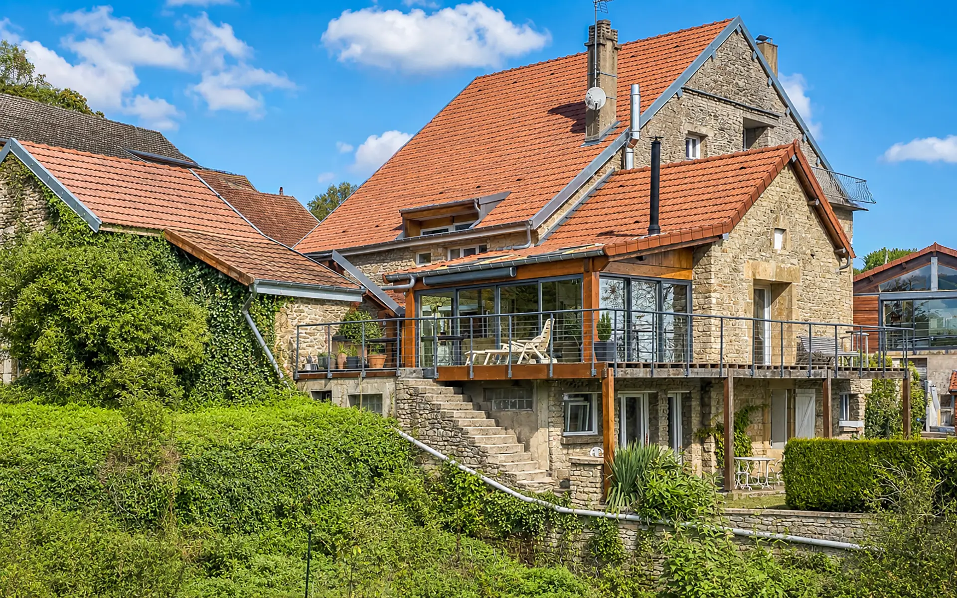 Façade et jardin de la maison vue sur lac proche de Langres à vendre - Arrière-Cour, agence immobilière spécialisée dans la Haute-Marne