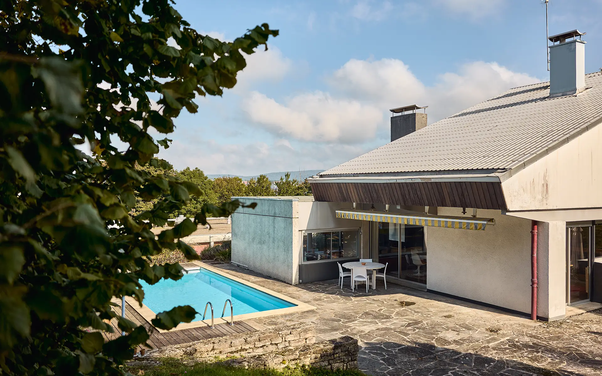 Façade et piscine de la maison d'architecte à Bregille à vendre - Arrière-Cour, agence immobilière spécialisée à Besançon