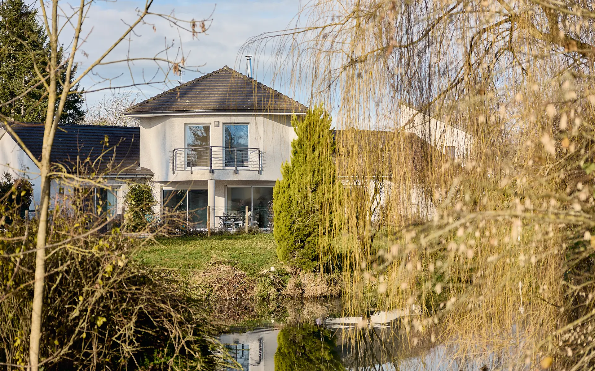 Façade et point d'eau de la propriété moderne et parc paysager près de Vesoul à vendre - Arrière-Cour, agence immobilière spécialisée en Haute-Saône
