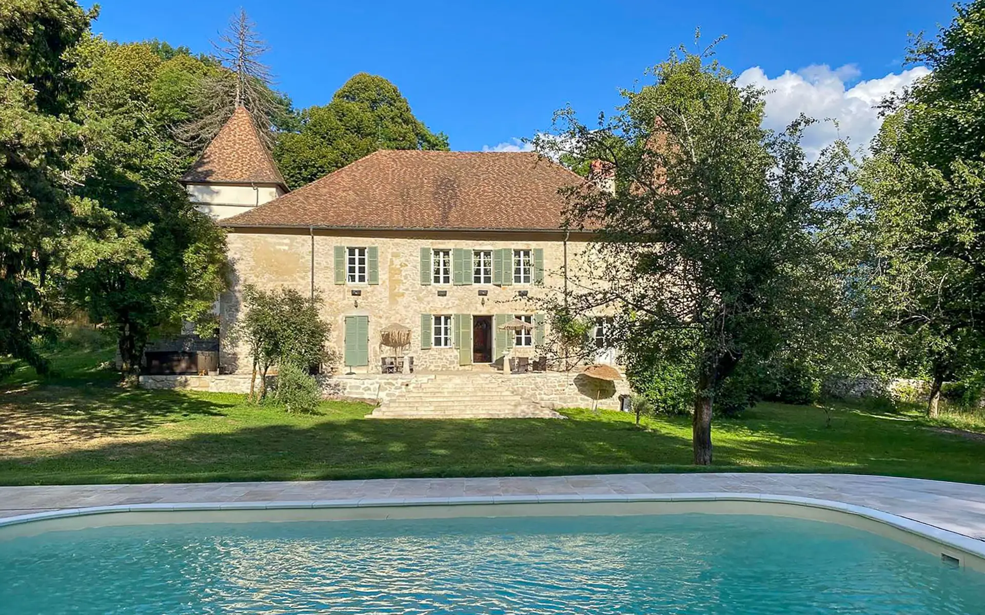 Façade et piscine du château Millénaire aux portes de Genève et du Pays de Gex à vendre - Arrière-Cour, agence immobilière spécialisée dans le Pays de Gex