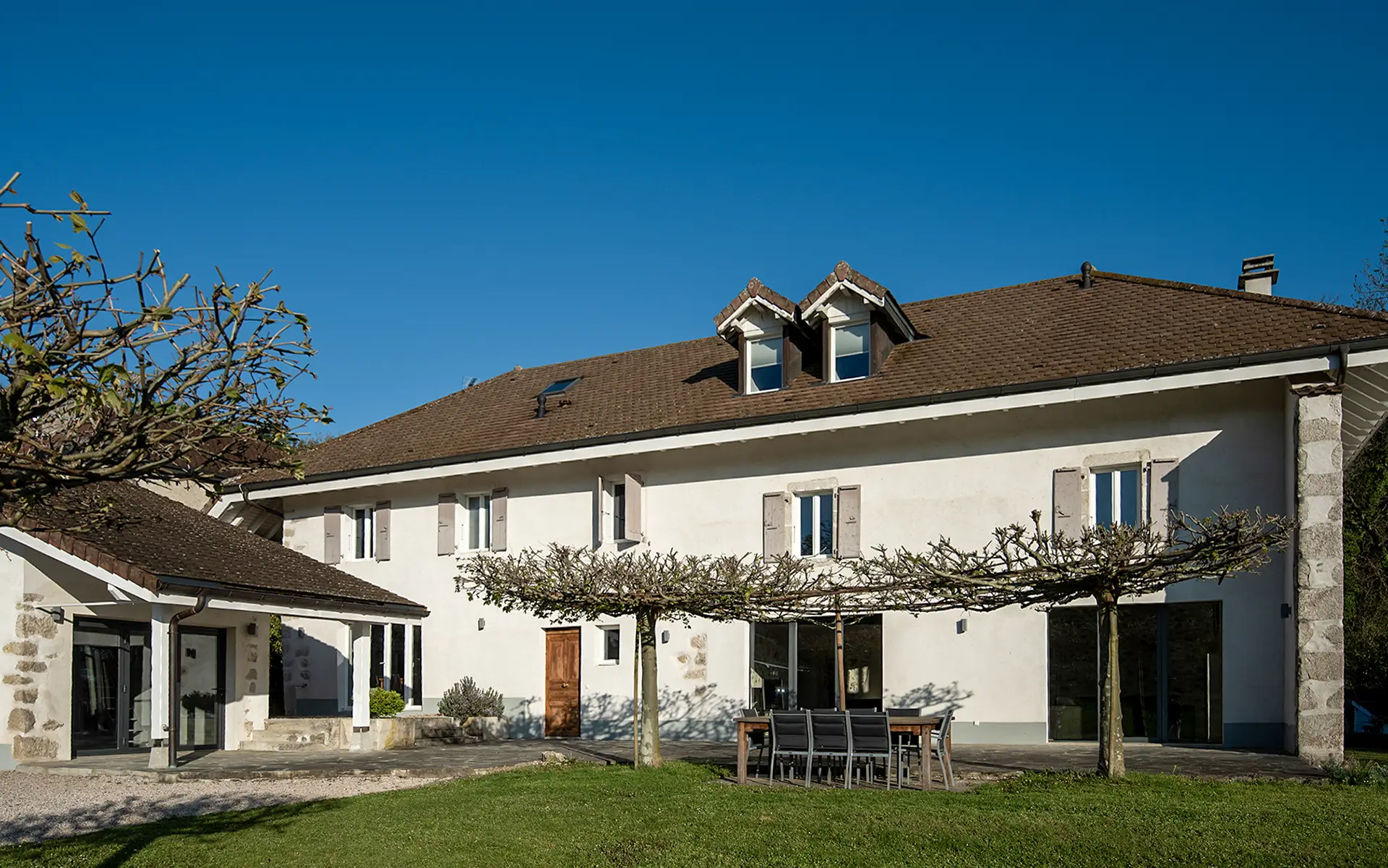Terrasse de l'ancienne ferme rénovée à Divonne-les-Bains dans le Pays de Gex à vendre - Arrière-Cour, agence immobilière spécialisée dans le Pays de Gex
