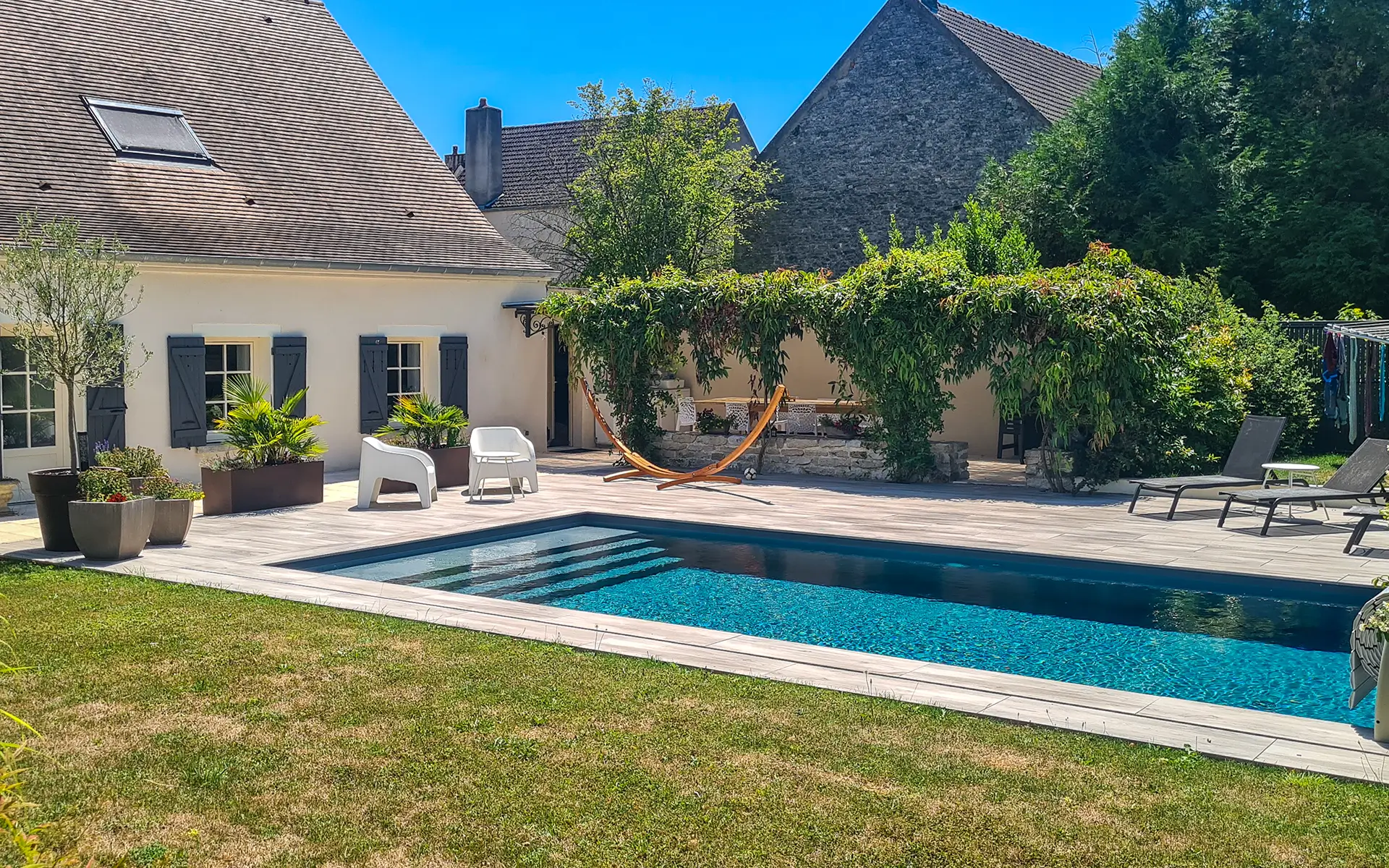 Façade et piscine de la maison de caractère à Gilly les Cîteaux, au cœur de la Côte de Nuits à vendre - Arrière-Cour, agence immobilière spécialisée en Bourgogne