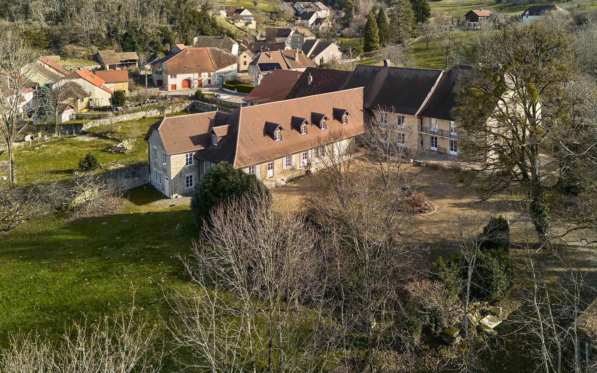 Vue d'ensemble de la maison vigneronne avec parc clos proche de la Château-Chalon à vendre - Arrière-Cour, agence immobilière spécialisée dans le Jura