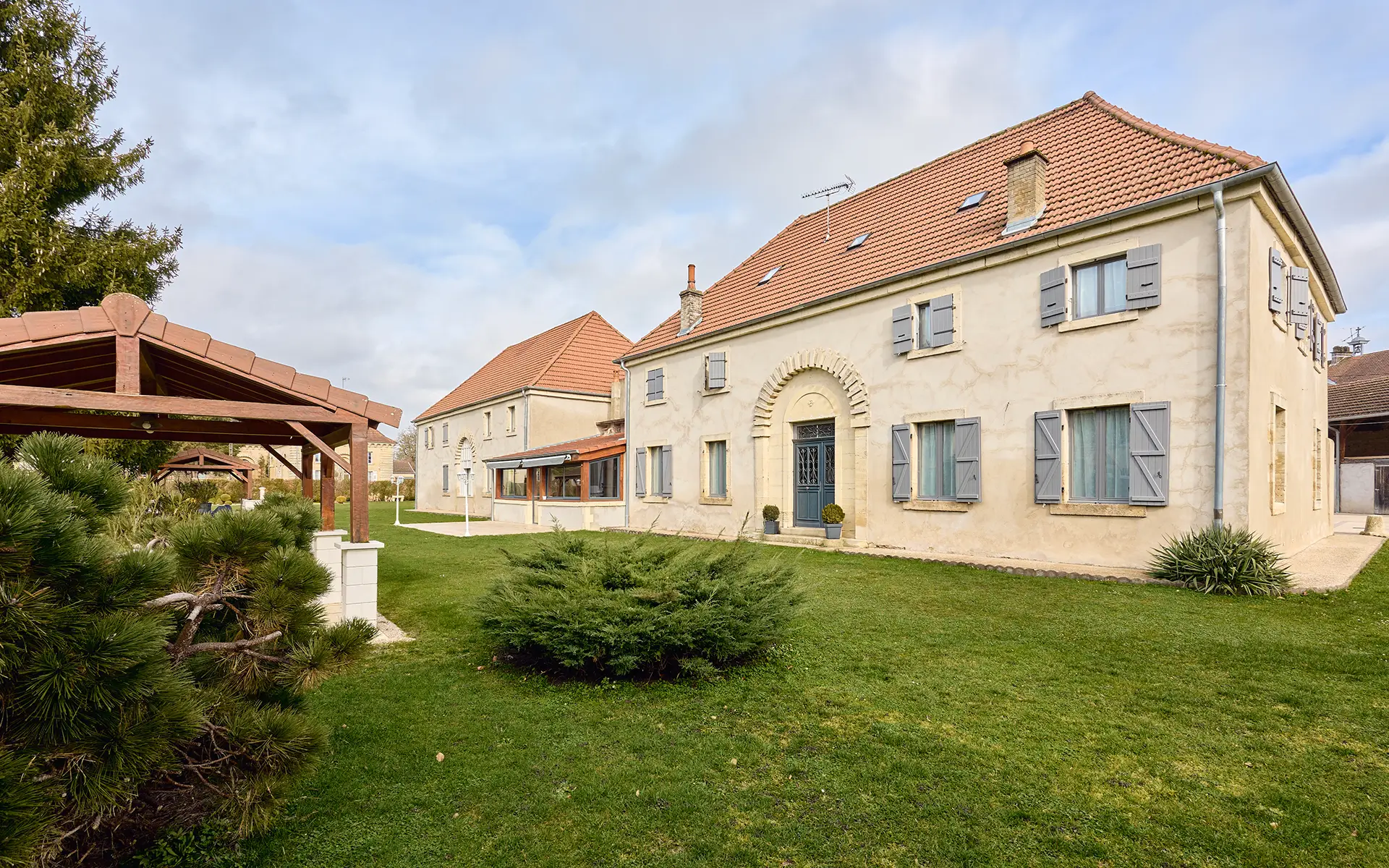 Façade et verdure du vaste domaine de caractère en Haute-Saône à vendre - Arrière-Cour, agence immobilière spécialisée en Haute-Saône