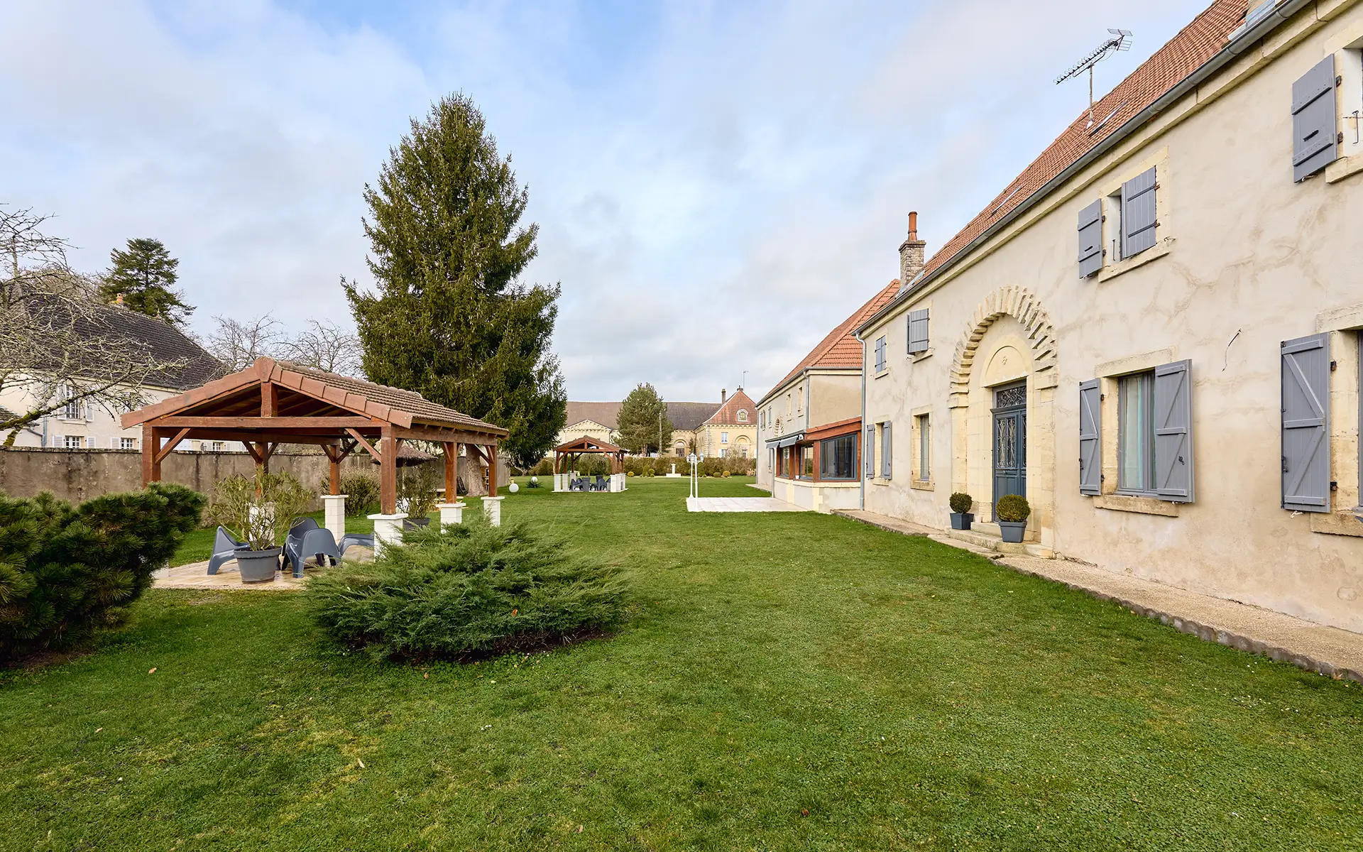 Jardin et façade du vaste domaine de caractère en Haute-Saône à vendre - Arrière-Cour, agence immobilière spécialisée en Haute-Saône