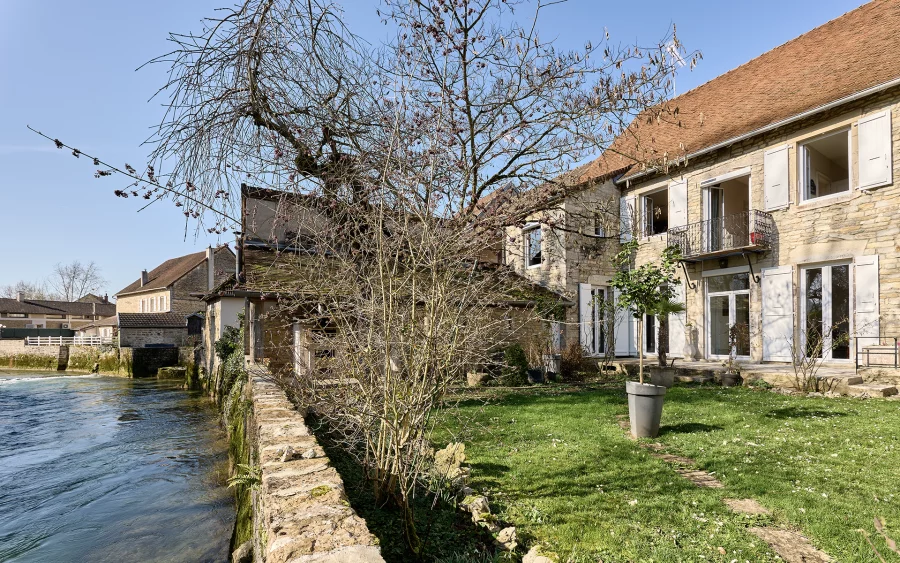 Façade lumineuse de la maison en pierre à Voiteur au bord de la Seille à vendre - Arrière-Cour, agence immobilière spécialisée dans le Jura