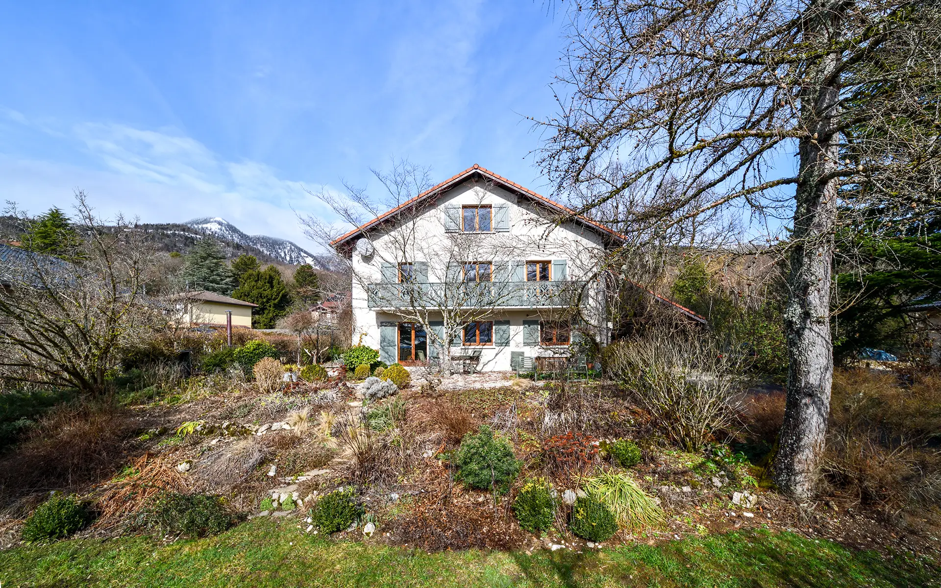 Façade lumineuse de la maison familiale avec jardin et vue à Gex à vendre - Arrière-Cour, agence immobilière spécialisée dans l'Ain