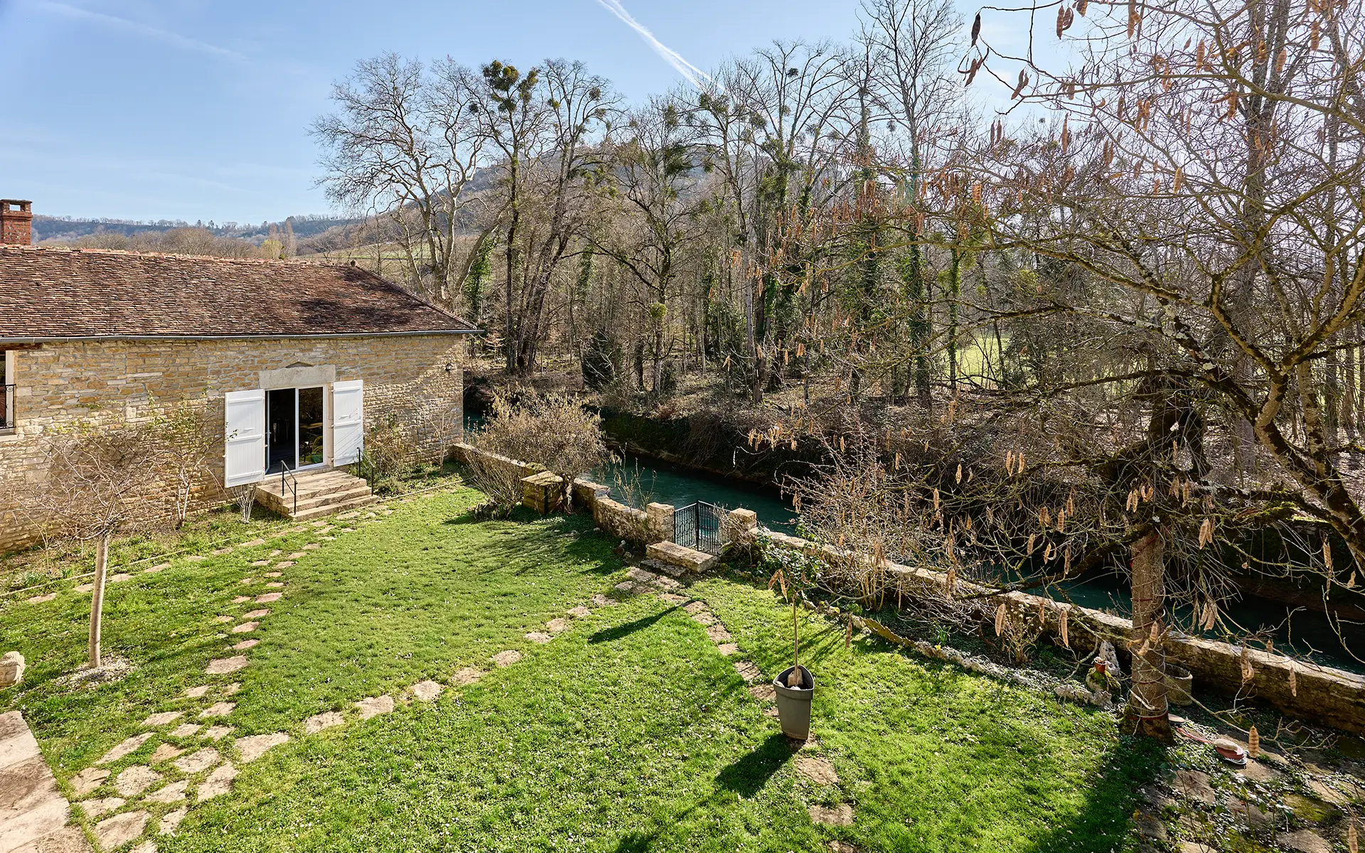 Jardin de la maison en pierre à Voiteur au bord de la Seille à vendre - Arrière-Cour, agence immobilière spécialisée dans le Jura