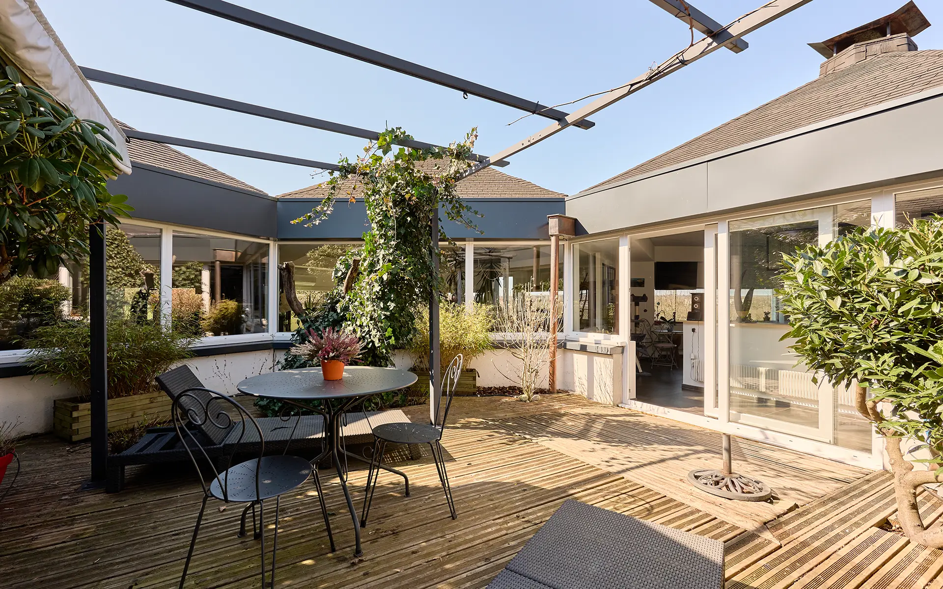 Patios et terrasse de la propriété atypique avec piscine intérieure et grands volumes proche Épinal à vendre - Arrière-Cour, agence immobilière spécialisée en les Vosges