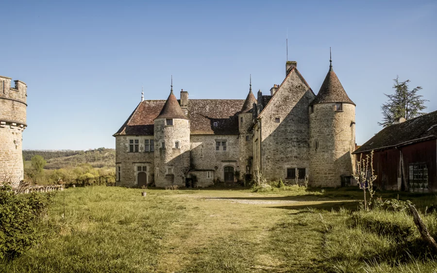 Façade et parc du domaine du XVe siècle à Domblans à vendre - Arrière-Cour, agence immobilière spécialisée dans le Jura