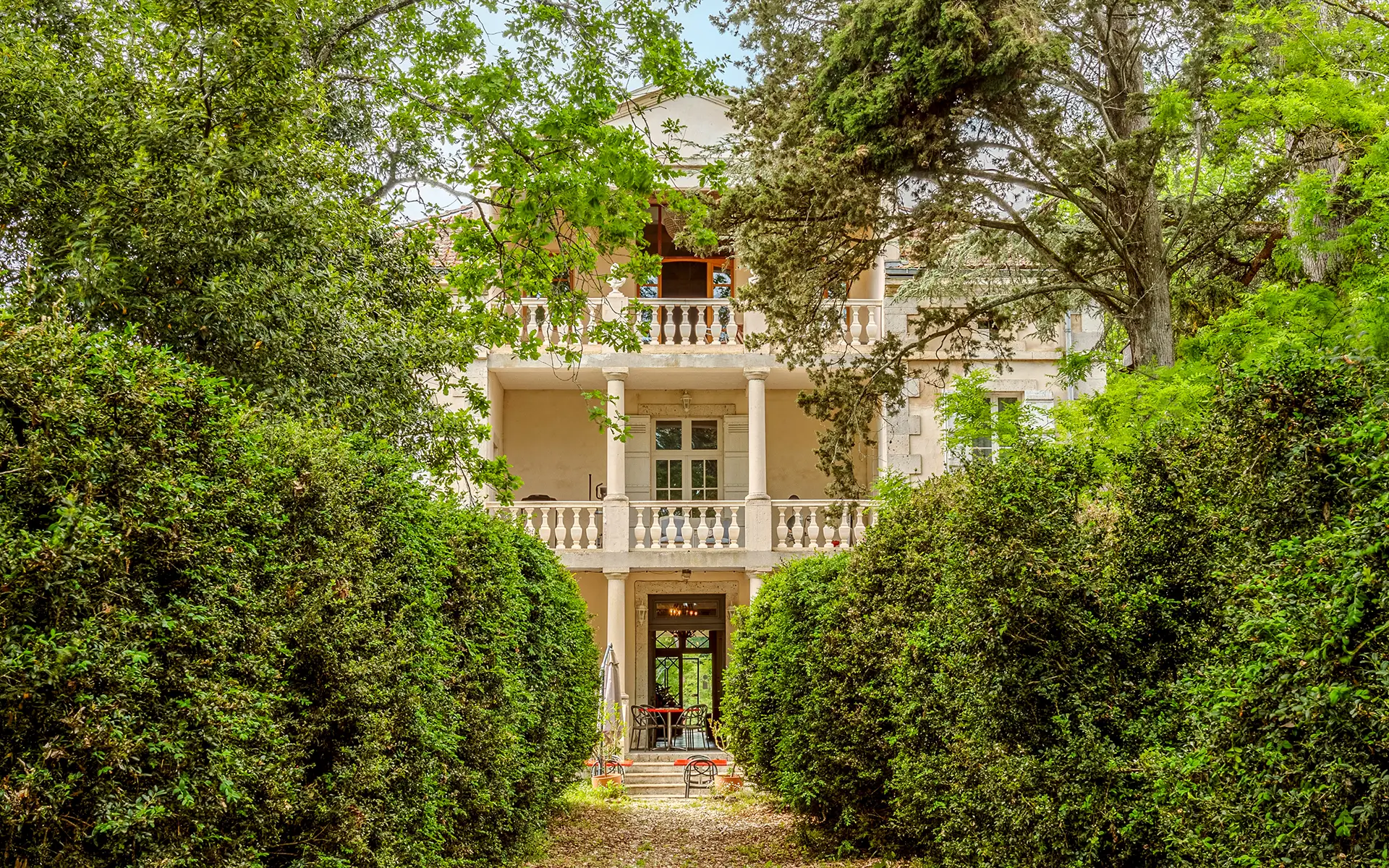 Façade et verdure du manoir néoclassique en Occitanie à vendre - Arrière-Cour, agence immobilière spécialisée en Occitanie