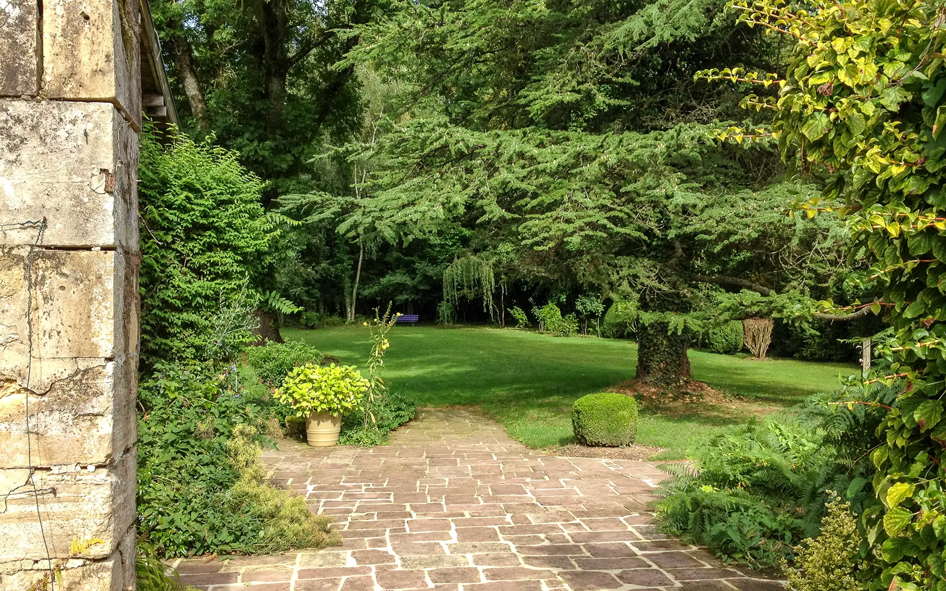 Façade et verdure de la propriété avec moulin ancien en Haute-Marne à vendre - Arrière-Cour, agence immobilière spécialisée en Haute-Marne