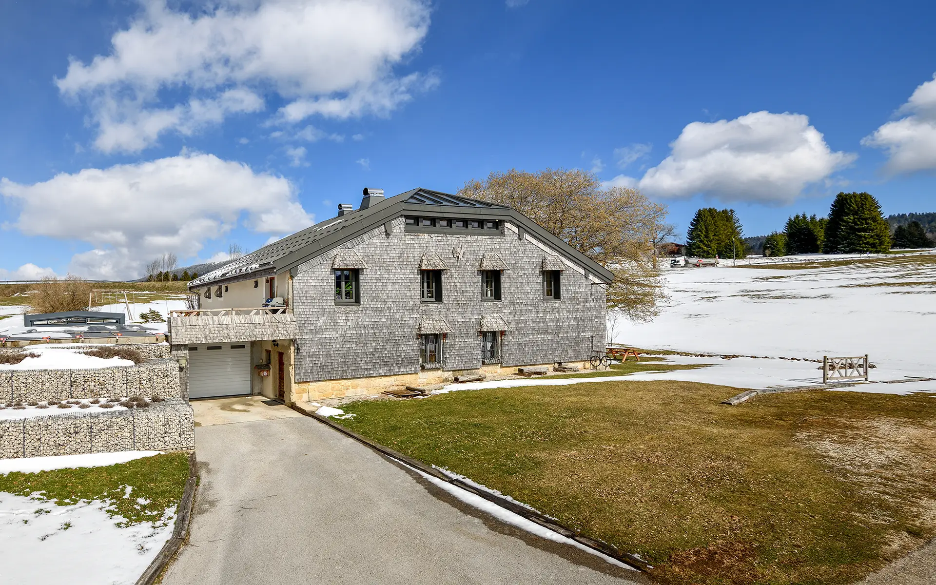 Façade de la ferme rénovée aux Rousses dans le Jura à vendre - Arrière-Cour, agence immobilière spécialisée dans le Jura