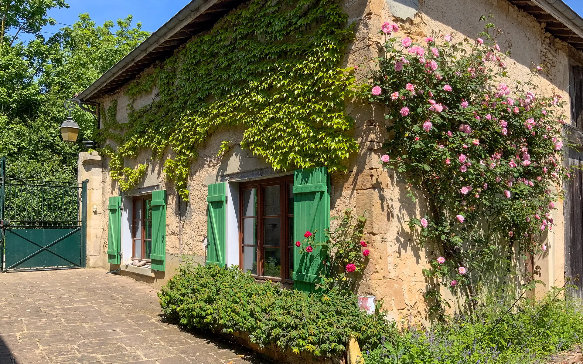 Façade fleuri de la propriété avec moulin ancien en Haute-Marne à vendre - Arrière-Cour, agence immobilière spécialisée en Haute-Marne