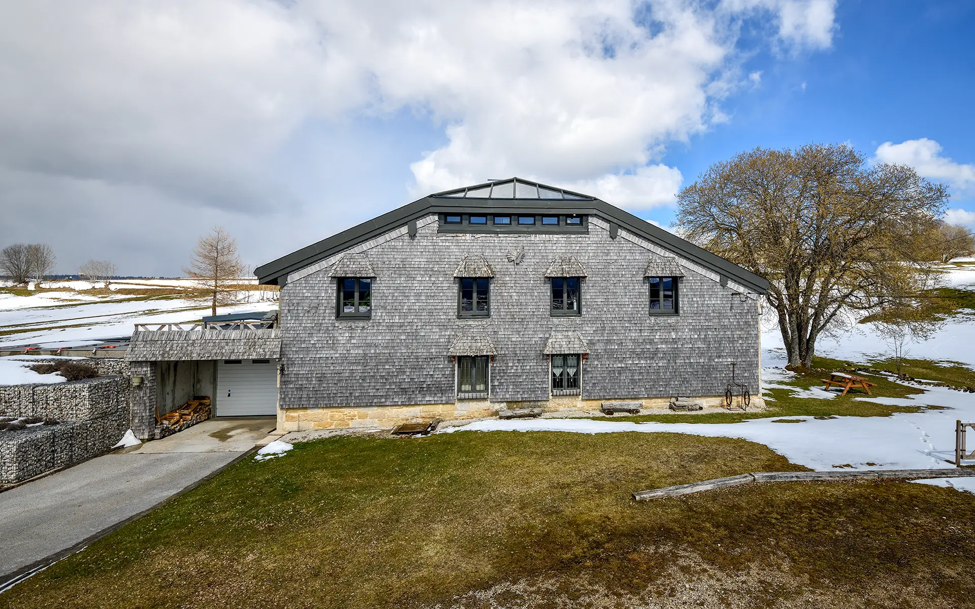 Façade lumineuse de la ferme rénovée aux Rousses dans le Jura à vendre - Arrière-Cour, agence immobilière spécialisée dans le Jura