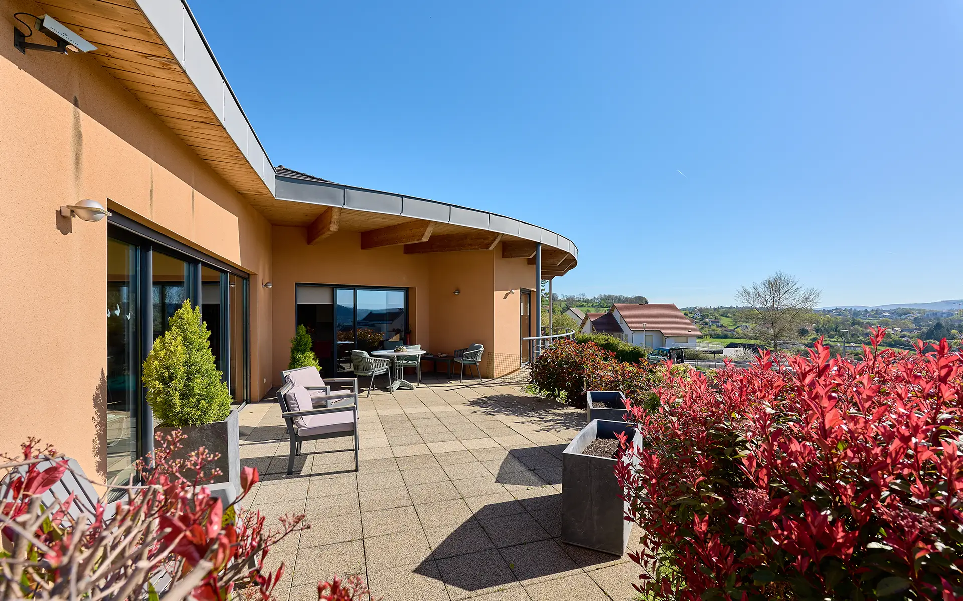 Façade et terrasse de la villa contemporaine sur les hauteurs des Montboucons à vendre - Arrière-Cour, agence immobilière spécialisée dans le Doubs