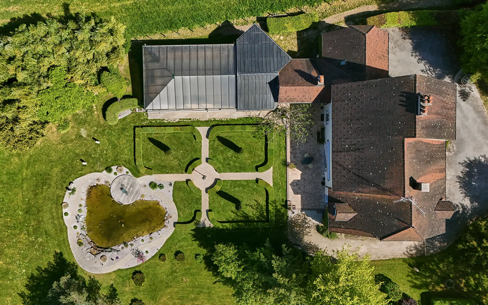Verdure et façade sur le Prieuré de l’étoile aux portes de Lons-le-Saunier à vendre - Arrière-Cour, agence immobilière spécialisée dans le Jura
