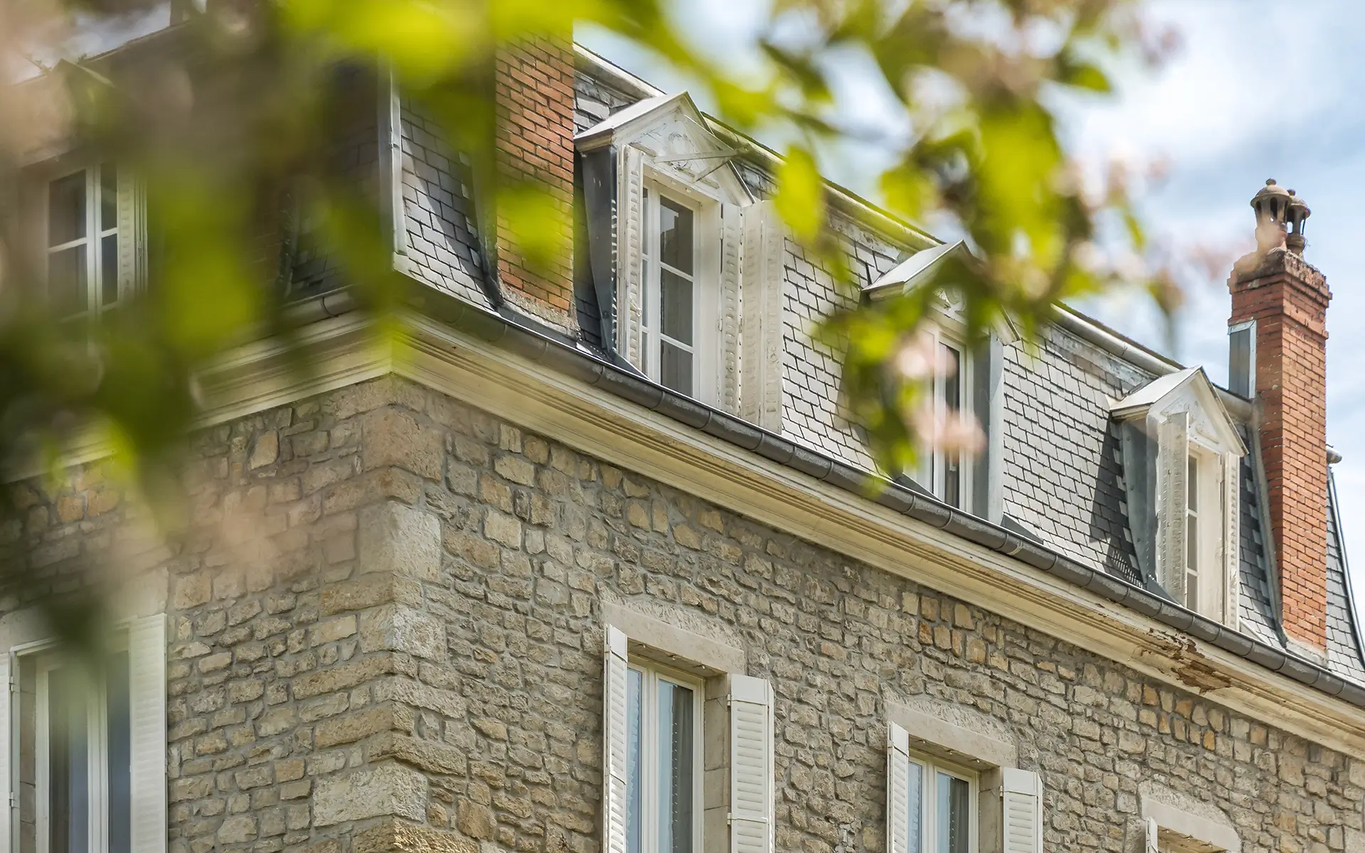 Façade en pierre de la maison de maître dans le vignoble à Voiteur à vendre - Arrière-Cour, agence immobilière spécialisée dans le Jura
