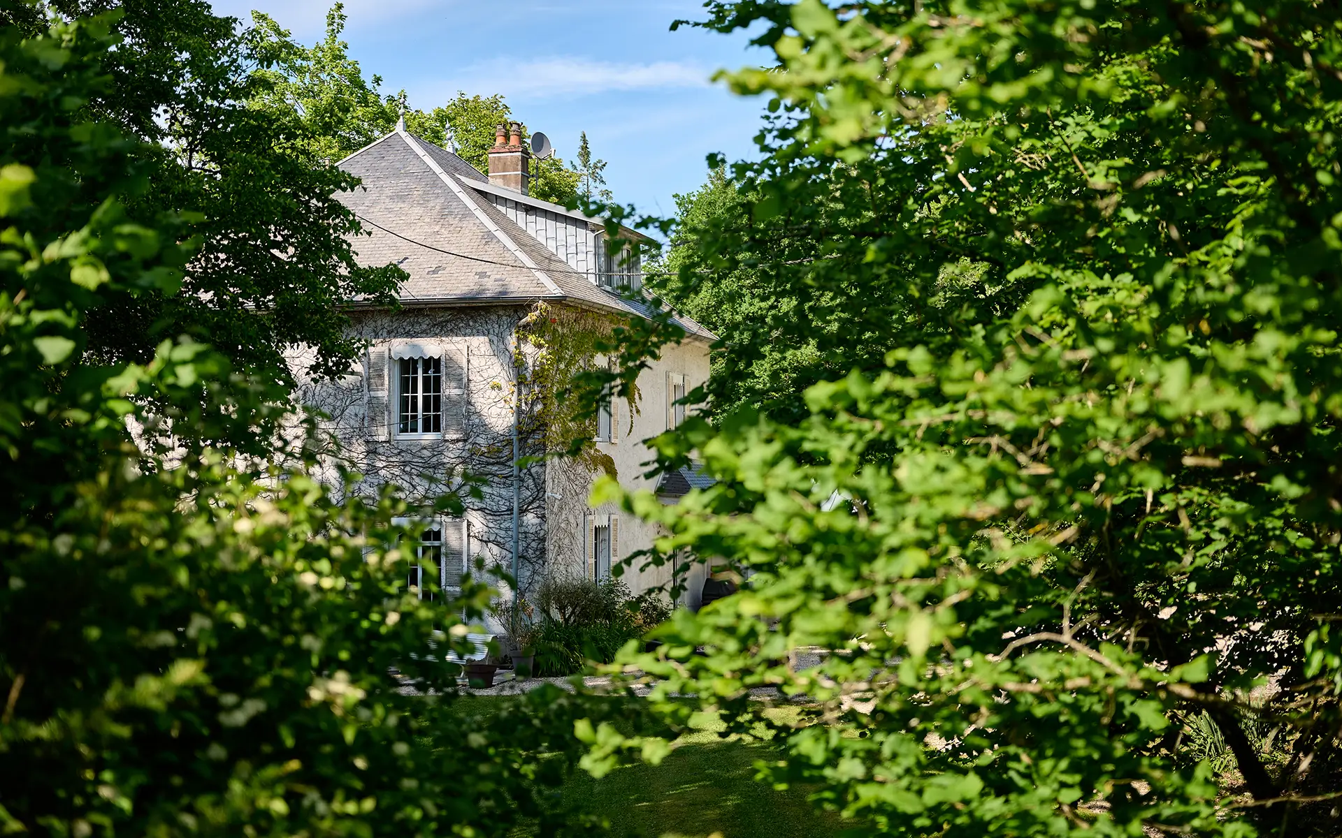 Façade et verdure de la maison de maître aux portes de Besançon à vendre - Arrière-Cour, agence immobilière spécialisée dans le Doubs