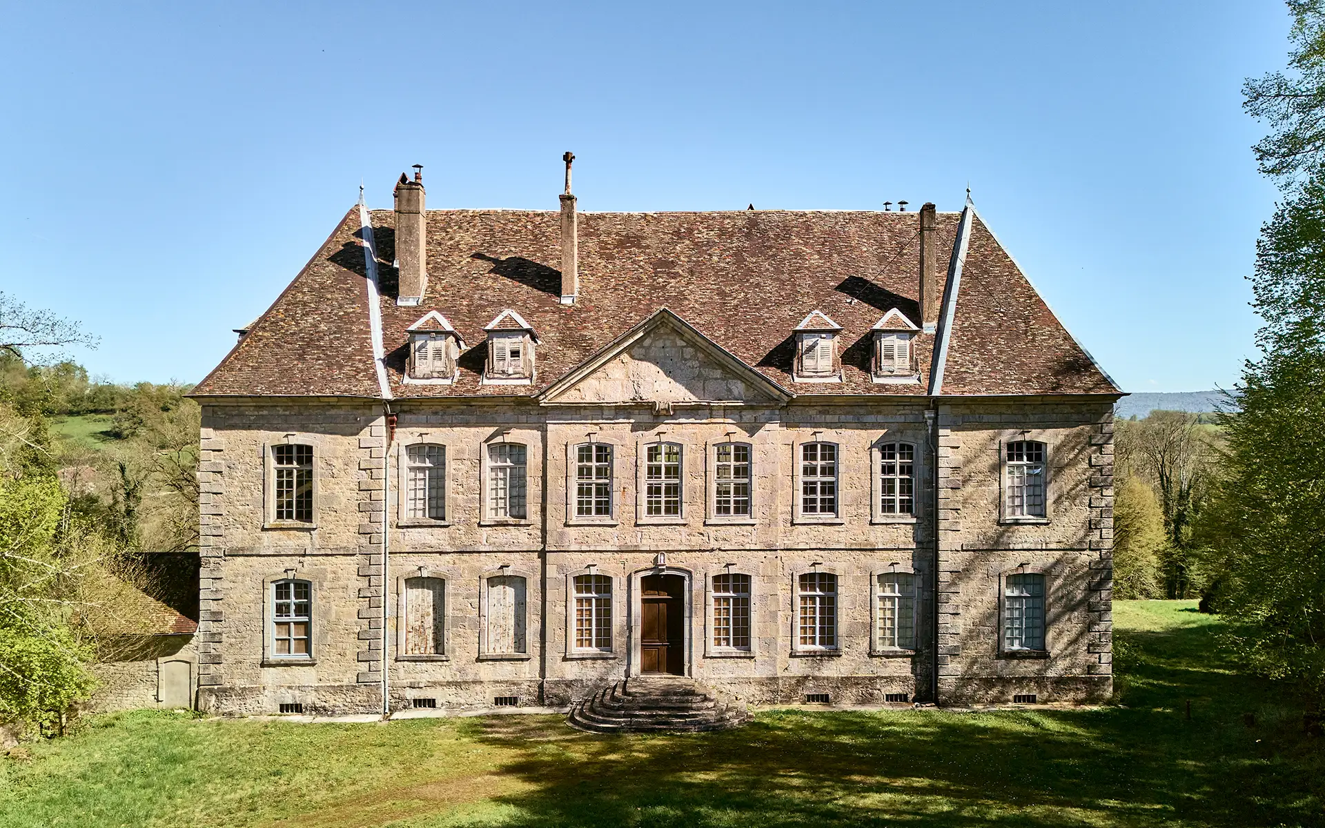 Façade lumineuse du château néo-classique à Sorans à vendre - Arrière-Cour, agence immobilière spécialisée en Haute-Saône