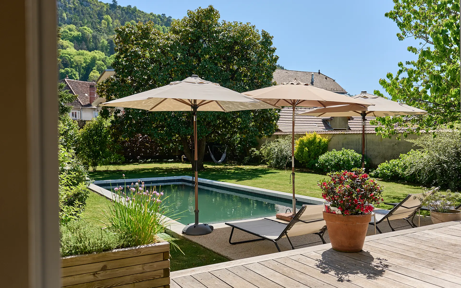 Terrasse et piscine de la maison de maître superbement rénovée à Poligny à vendre - Arrière-Cour, agence immobilière spécialisée dans le Jura