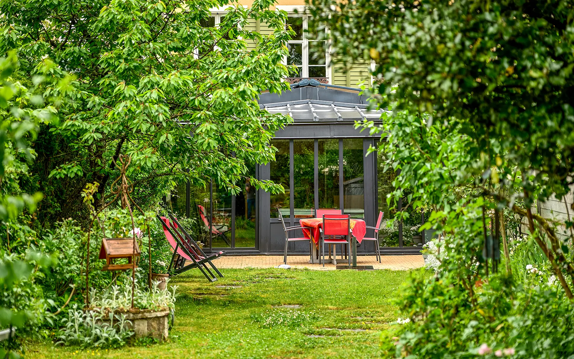 Verdure et véranda de la maison du XVIIIe siècle à Montbéliard à vendre - Arrière-Cour, agence immobilière spécialisée dans le Doubs